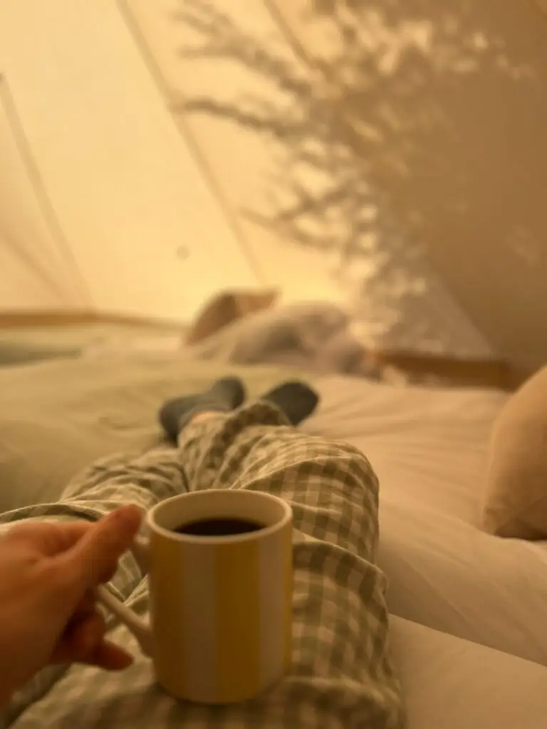 Inside an Essentials bell tent, morning coffee in bed