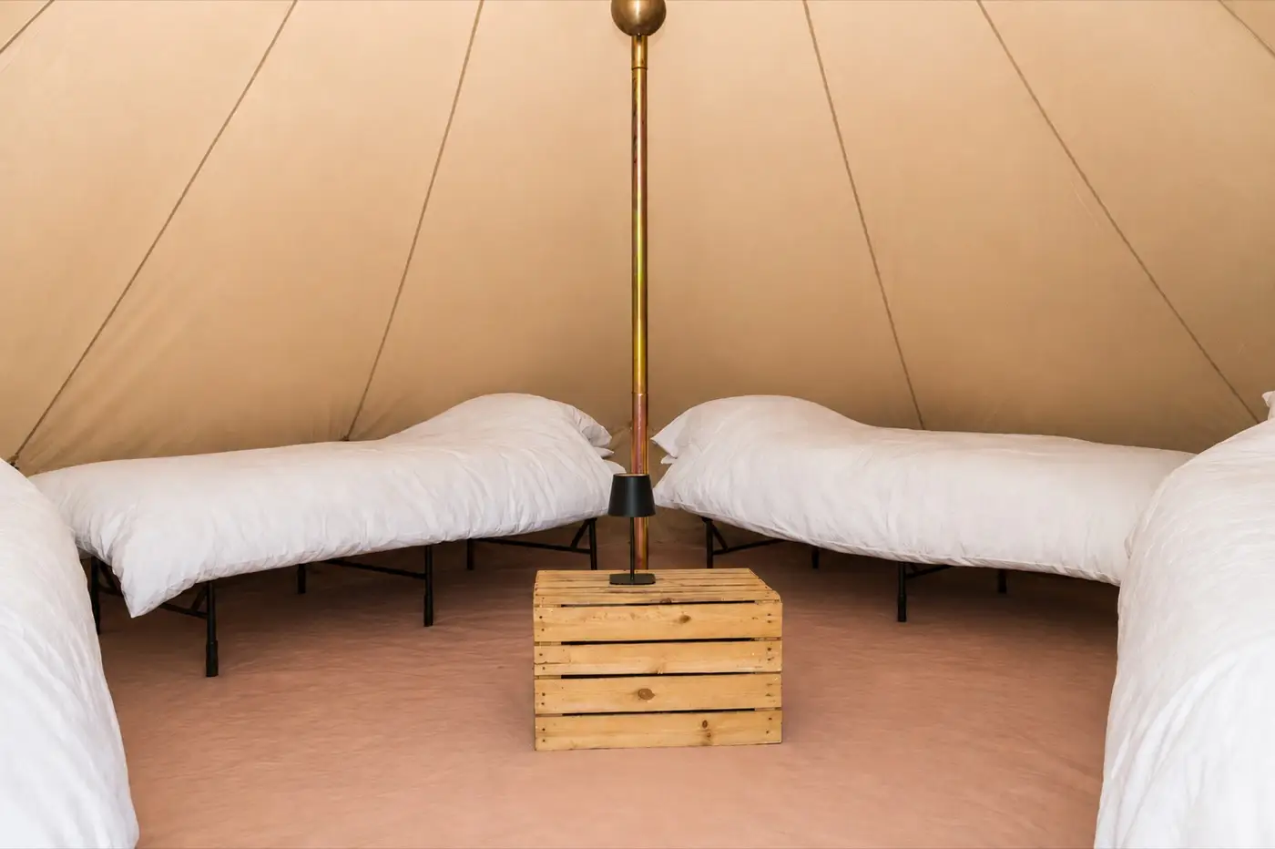 Essentials interior with four real beds made up around an apple crate