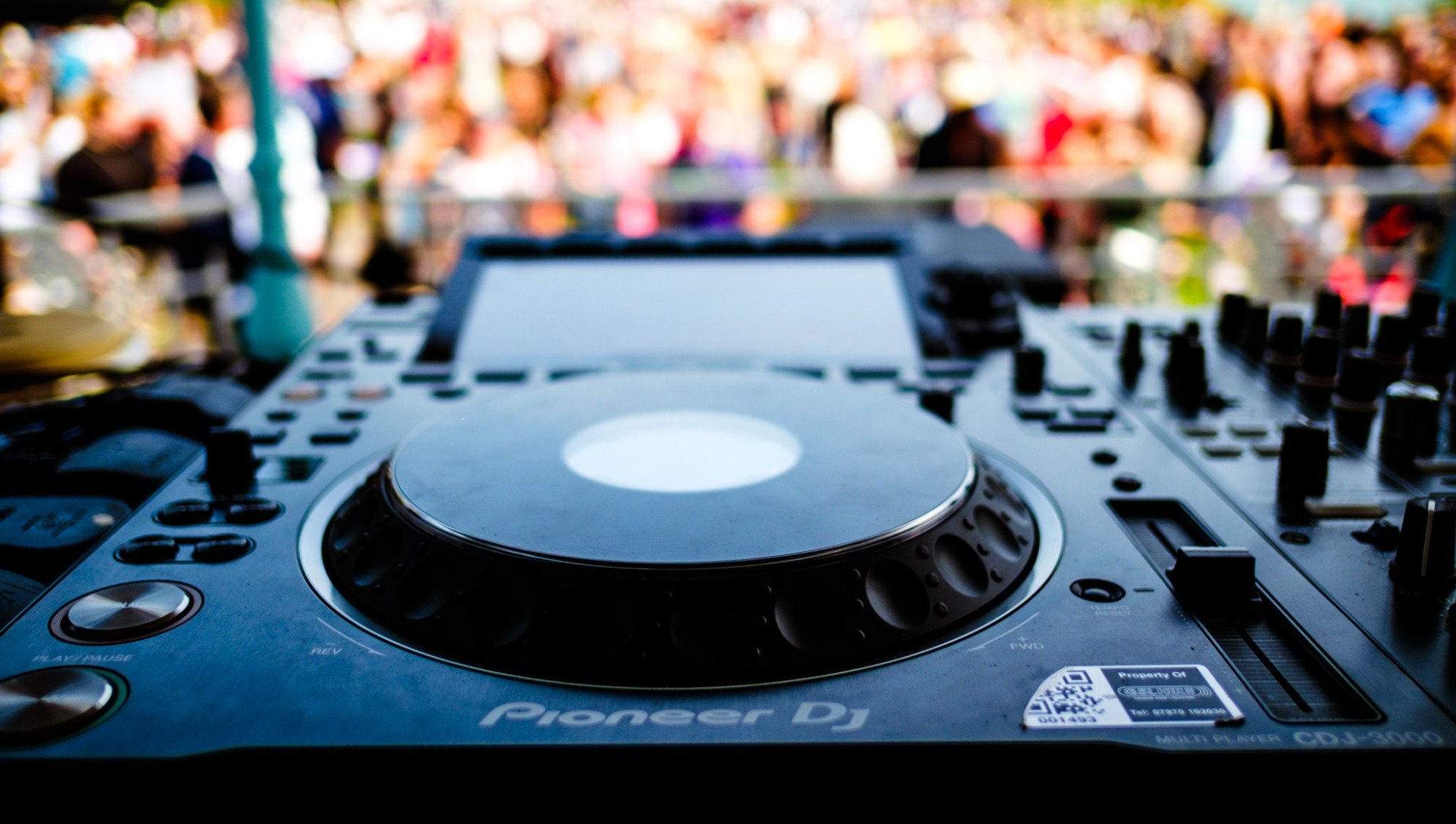 DJ decks on stage at Love On, with the crowd behind